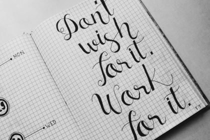 Close-up of motivational calligraphy on grid paper, inspiring message for productivity.